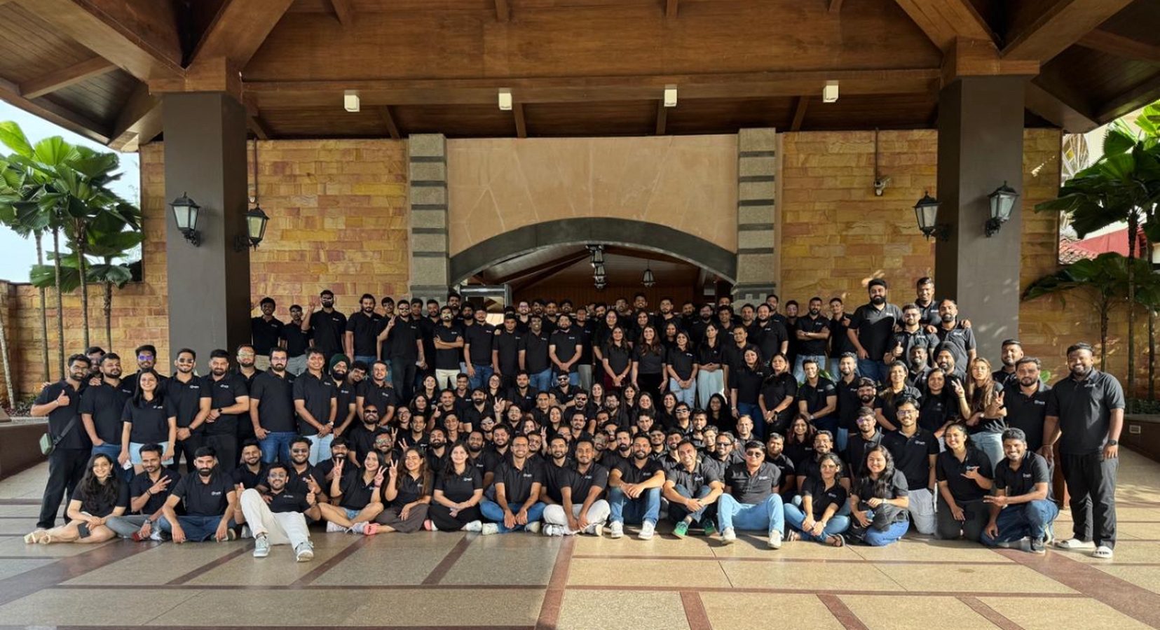 A large team photo on the steps of a resort pavilion