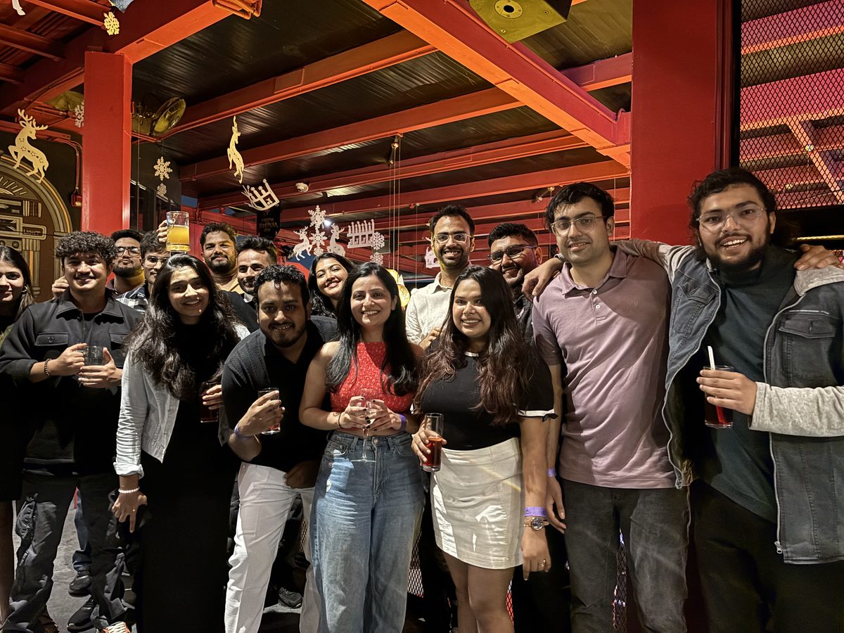 A group posing together on a night out under a red-beamed ceiling